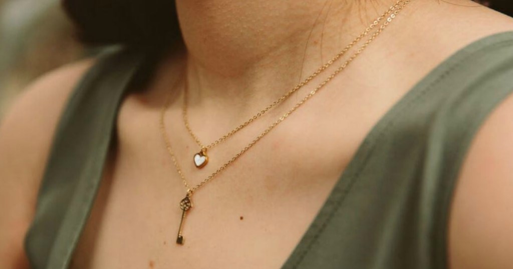 woman's neck with 2 necklaces with tank top