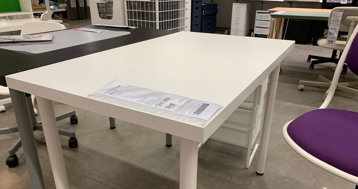 white tabletop with legs desk sitting in store 
