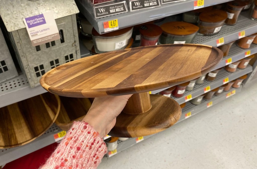 hand holding wooden cake stand in store