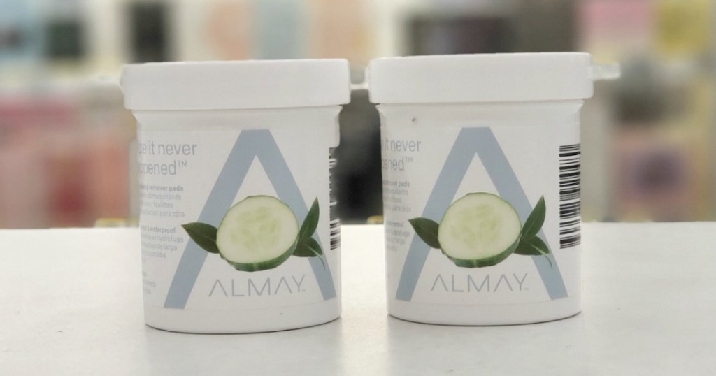 Two containers of Almay brand eye makeup remover pads on counter in store