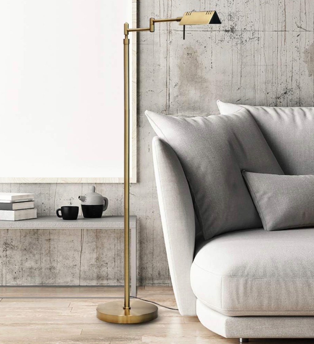 gold task floor lamp in styled living room with gray couch