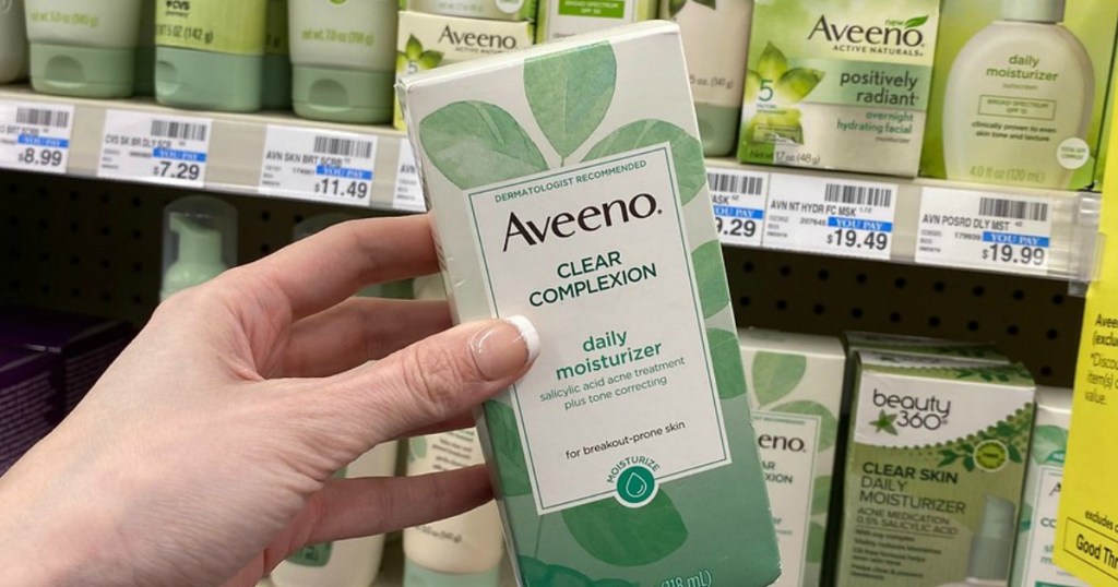 Hand holding up Aveeno Clear Complexion Moisturizer at CVS