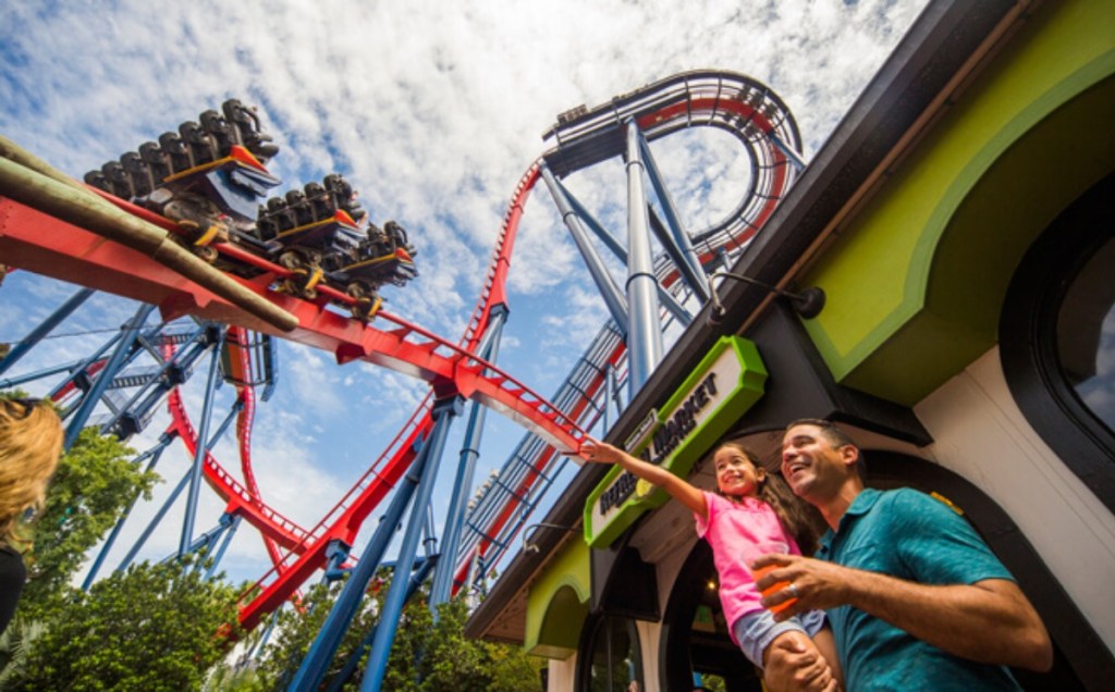 Father holding daughter under roller coaster