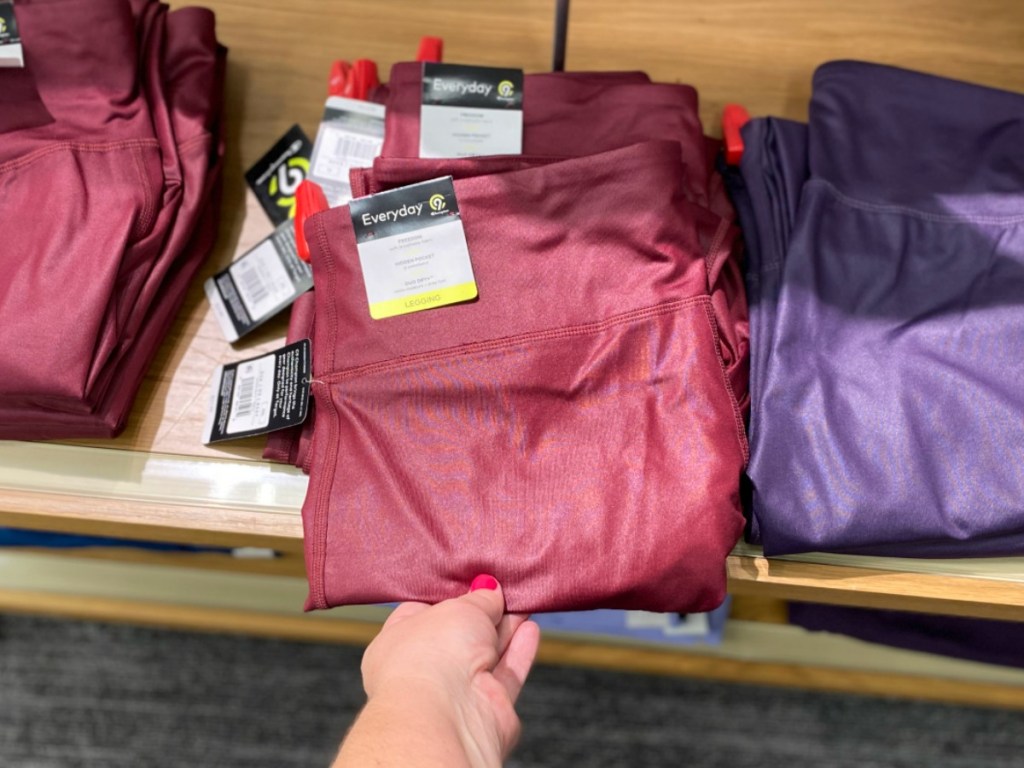 Women's athletic pants folded in hand near in-store display