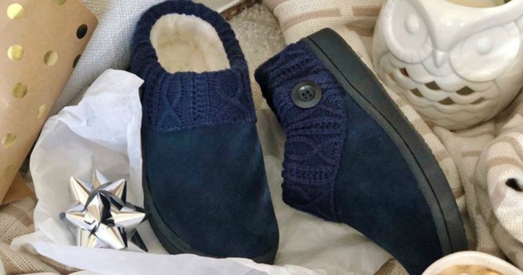 navy blue slippers that have a fuzzy inside sitting on wrapping paper