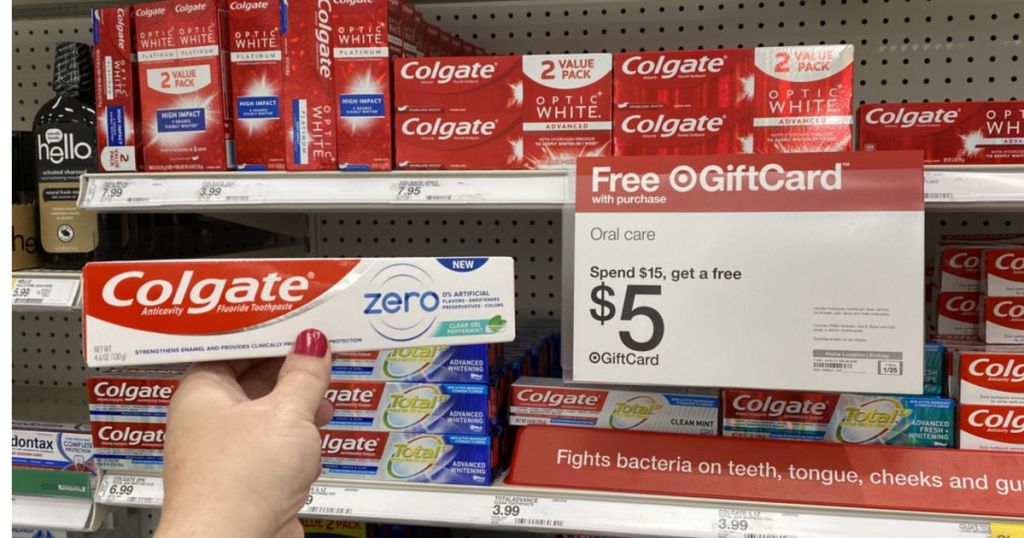 hand holding pack ofColgate Zero Toothpaste in front of Target Sign