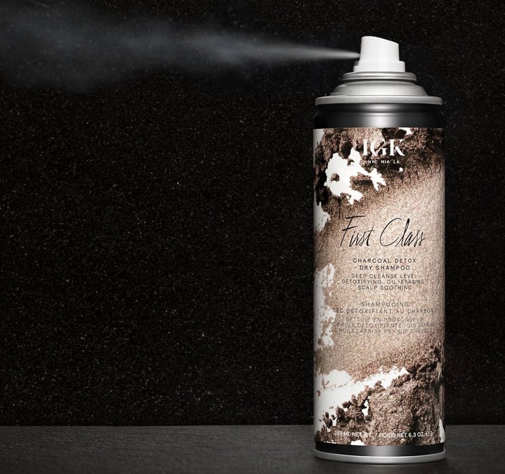 First Class Dry Shampoo spraying onto a black background