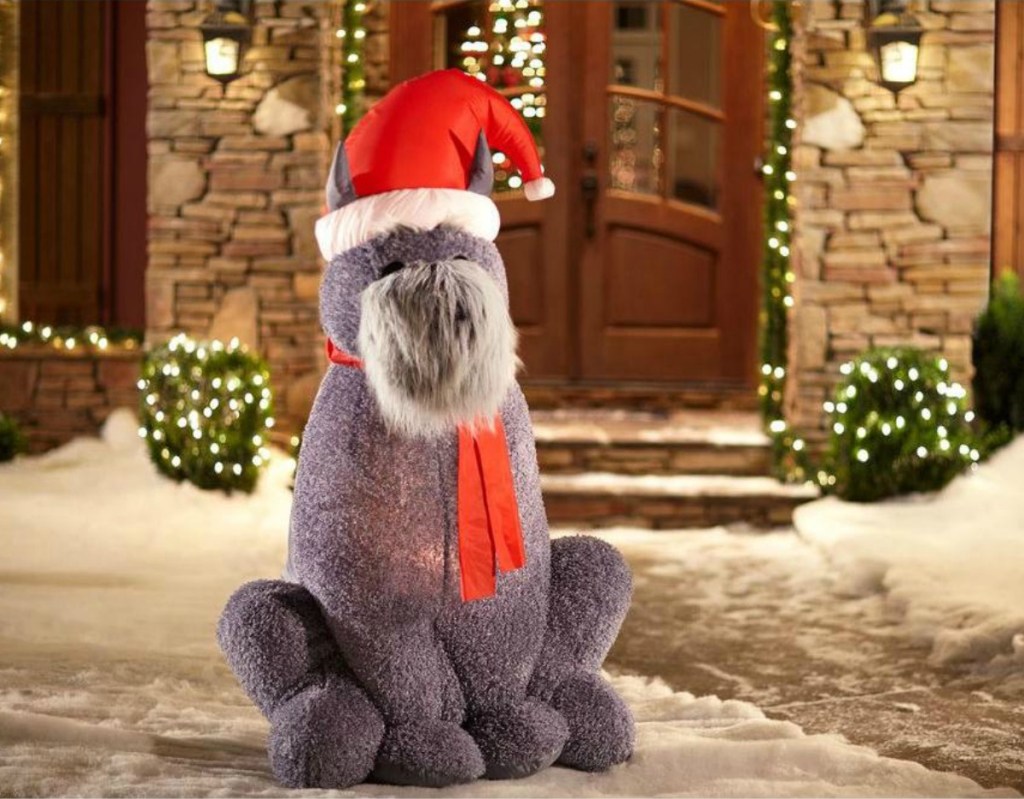 Inflatable dog wearing winter hat and scarf in front of doorstep