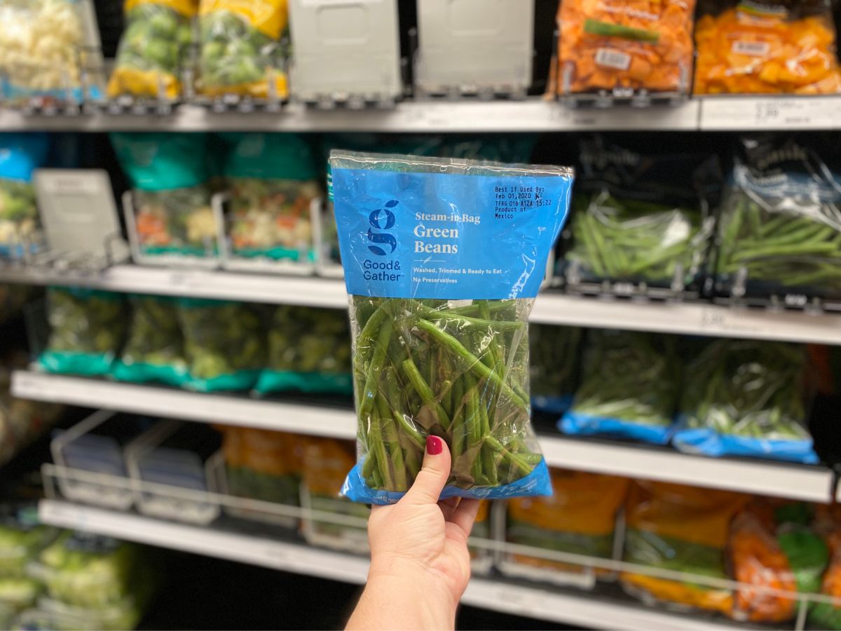 hand holding good & gather green beans bag in store