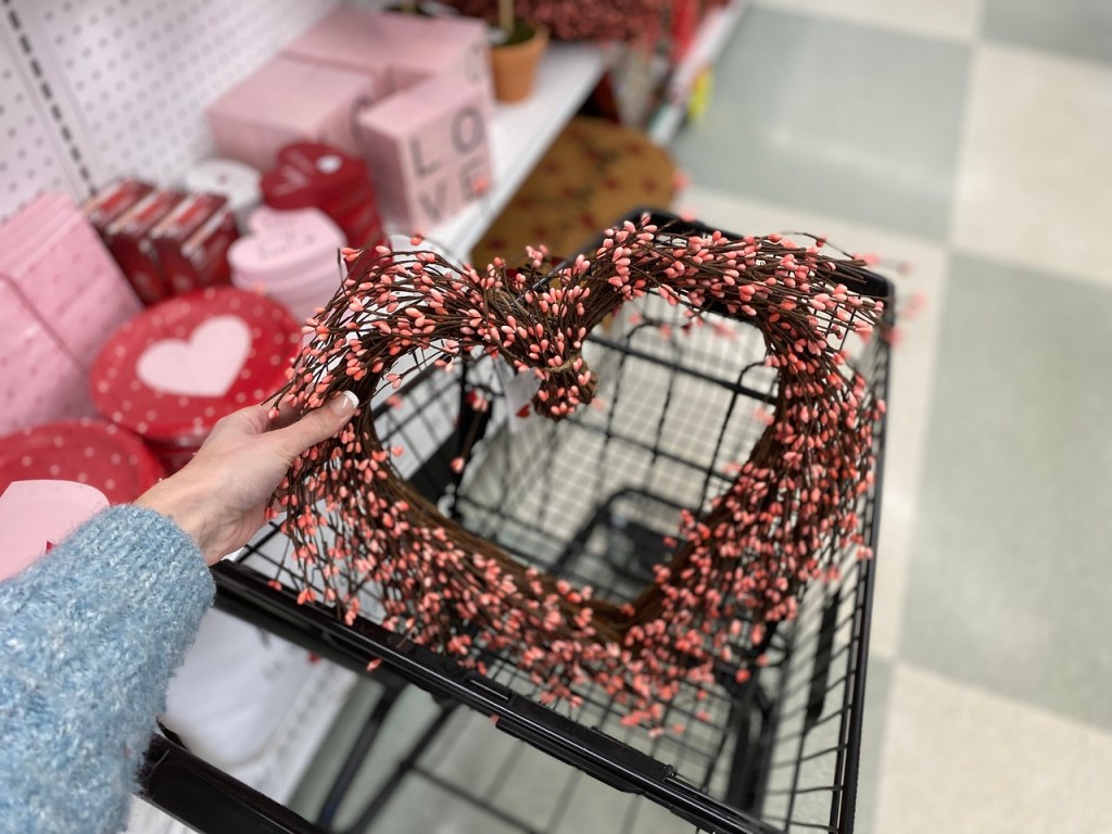 Hand Holding up Heart Wreath in front of cart at Joann fabrics