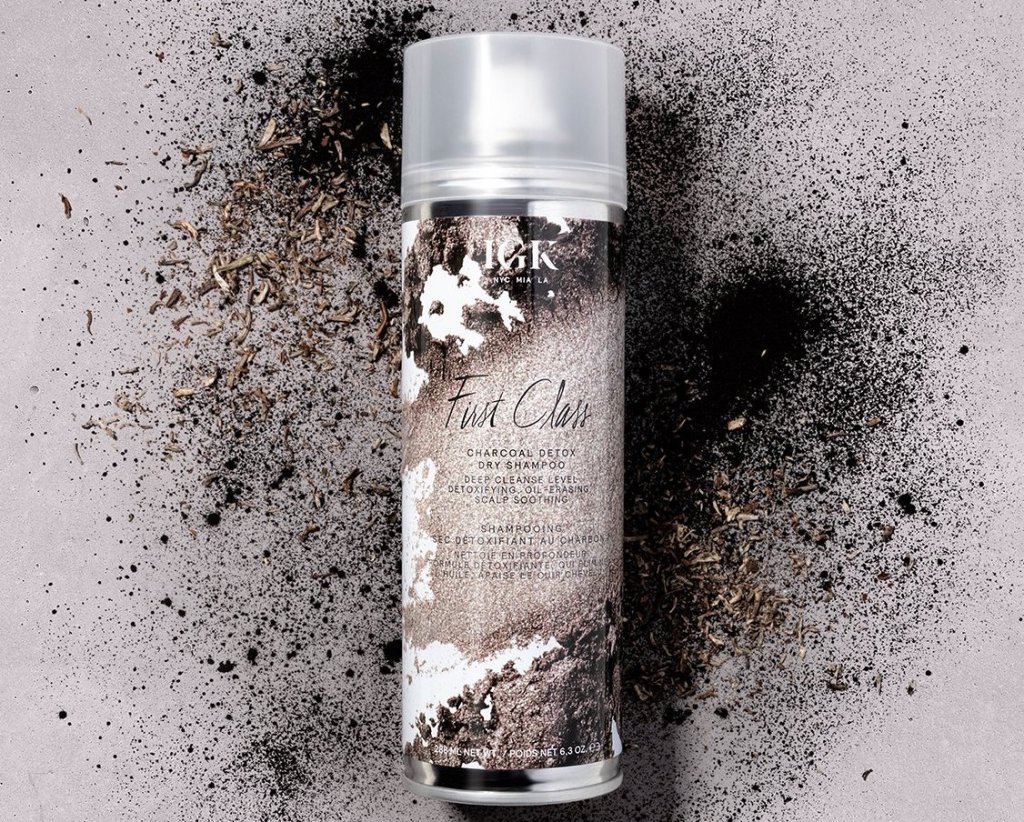 IGK Hair First Class Dry Shampoo laying on charcoal