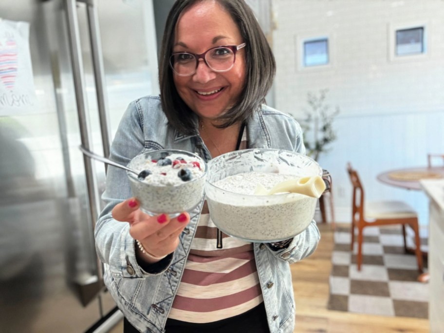 woman holding a small dish of chia seed overnight oats next to a large dish of it