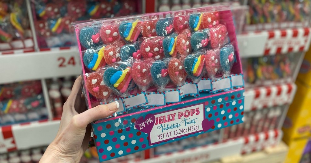 woman holding Jelly Pops Valentine Treats 24-pack containing gummy hearts with rainbows or heart decoration on them
