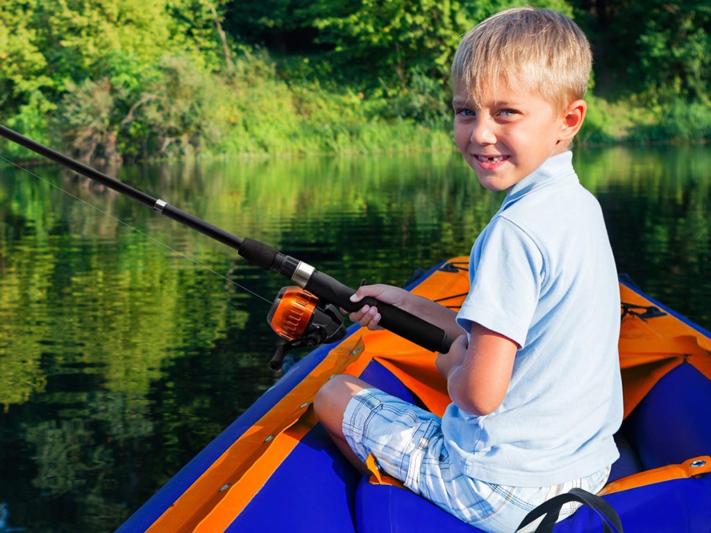 Little Boy sitting in a boat holding a fishing pole