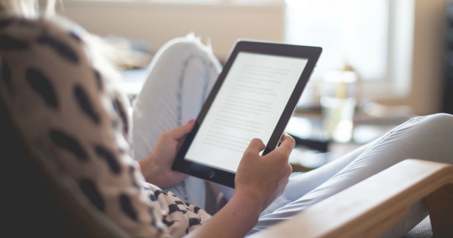 Woman reading Kindle while sitting chair