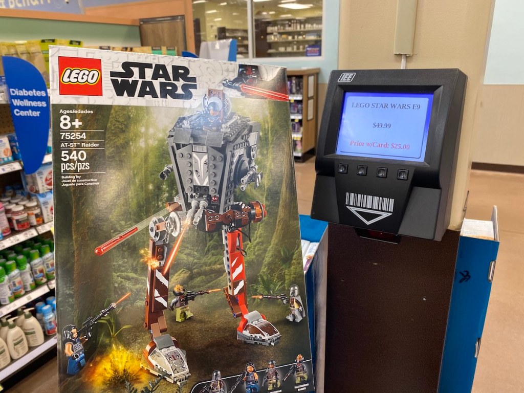 Hand holding Star Wars LEGO At-St next to Kroger scanner