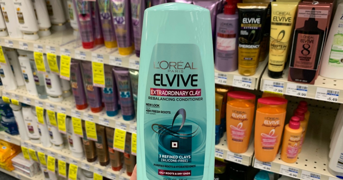 Hand holding shampoo in front of shelf