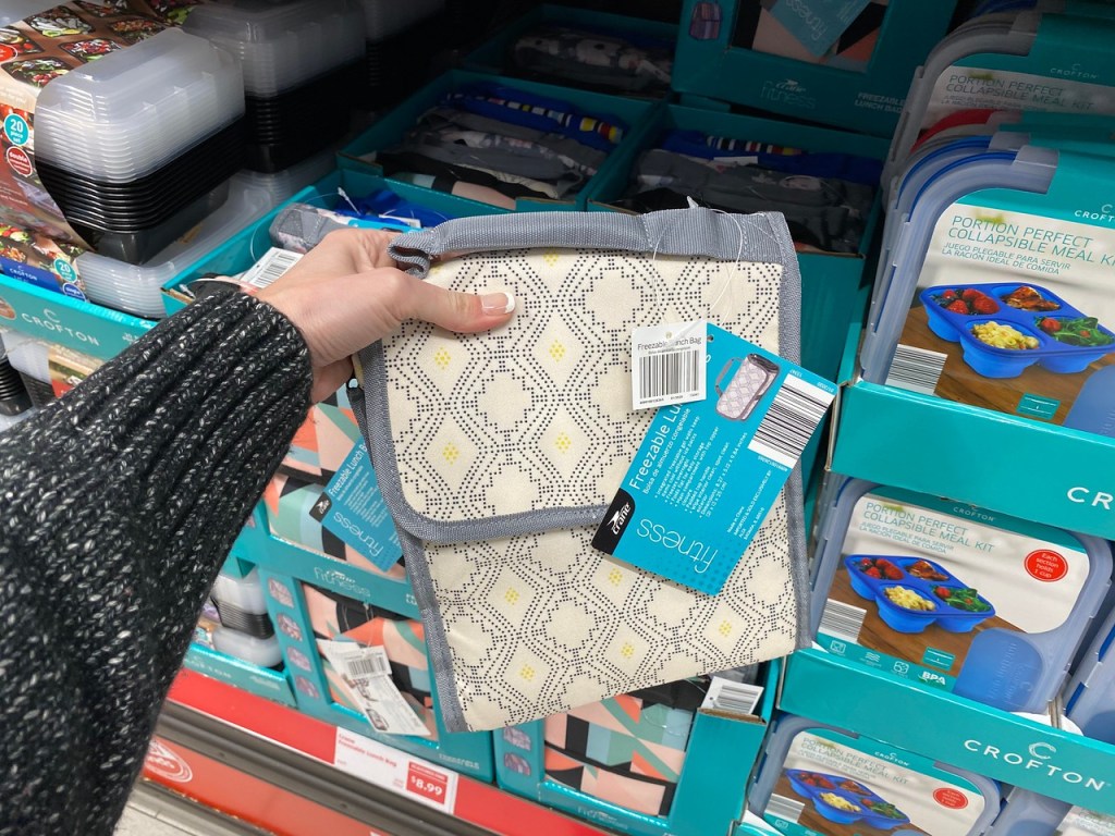 Hand holding up freezable lunch bag at ALDI