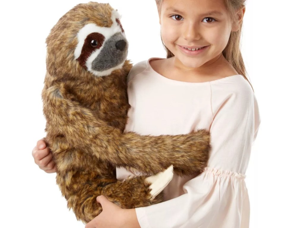 Little Girl holding Melissa & Doug stuffed Sloth 