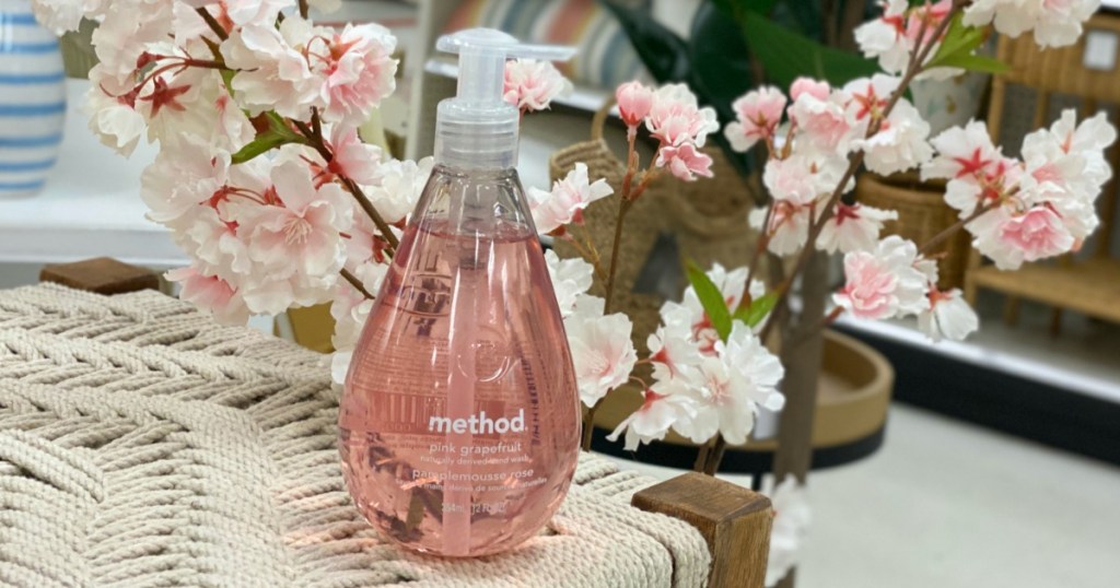 Method Pink Grapefruit Hand Soap next to cherry blossoms on table