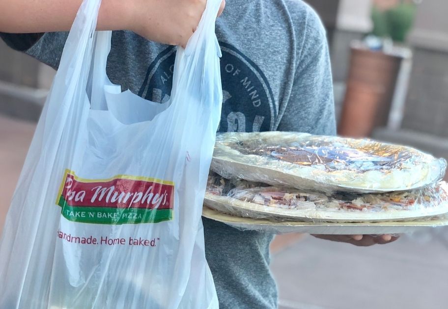 boy holding a Papa Murphy's bag and pizzas