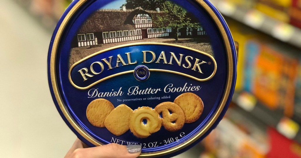 woman holding up a Royal Dansk cookie tin