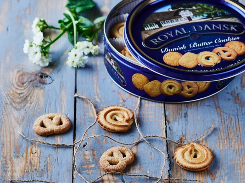 Royal Dansk cookie tin and cookies on a wooden background with flowers and twine