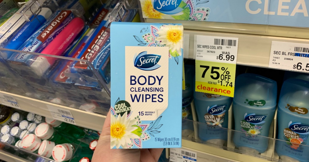 Hand holding Secret body wipes in front of shelf 