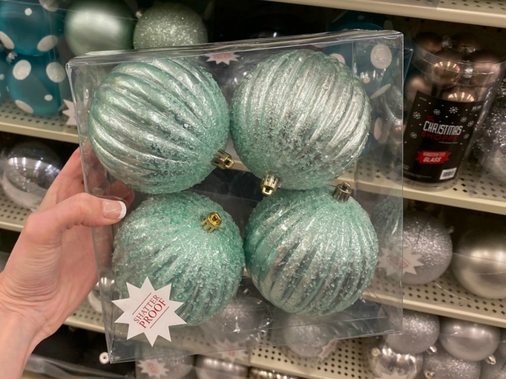 Teal colored Christmas ornaments in package in hand in-store