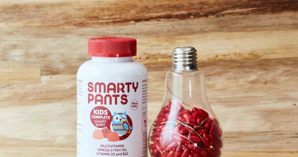 Smarty Pants kids gummy vitamins next to a light bulb full of vitamin capsules