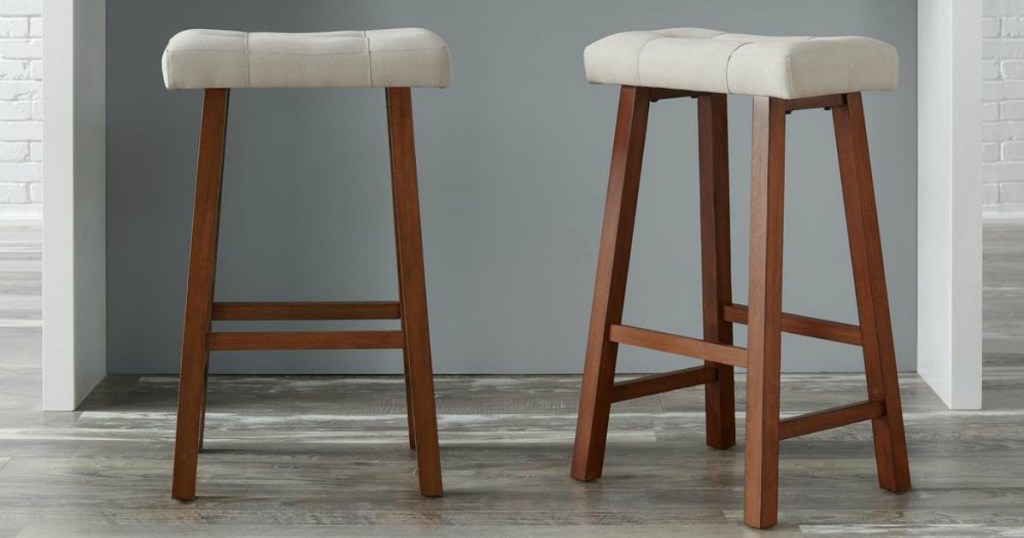 two wooden barstools with white seats