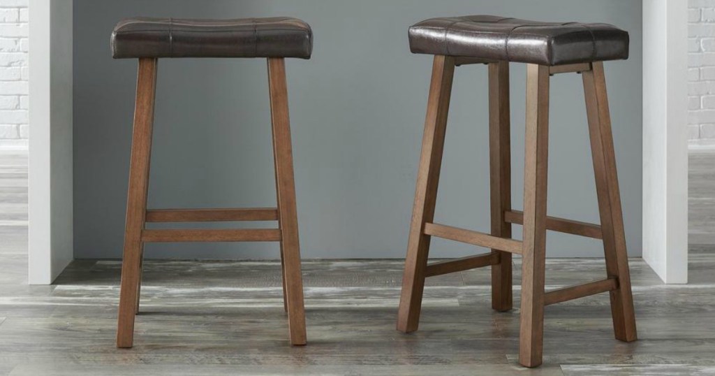 two wooden bar stools with brown seats