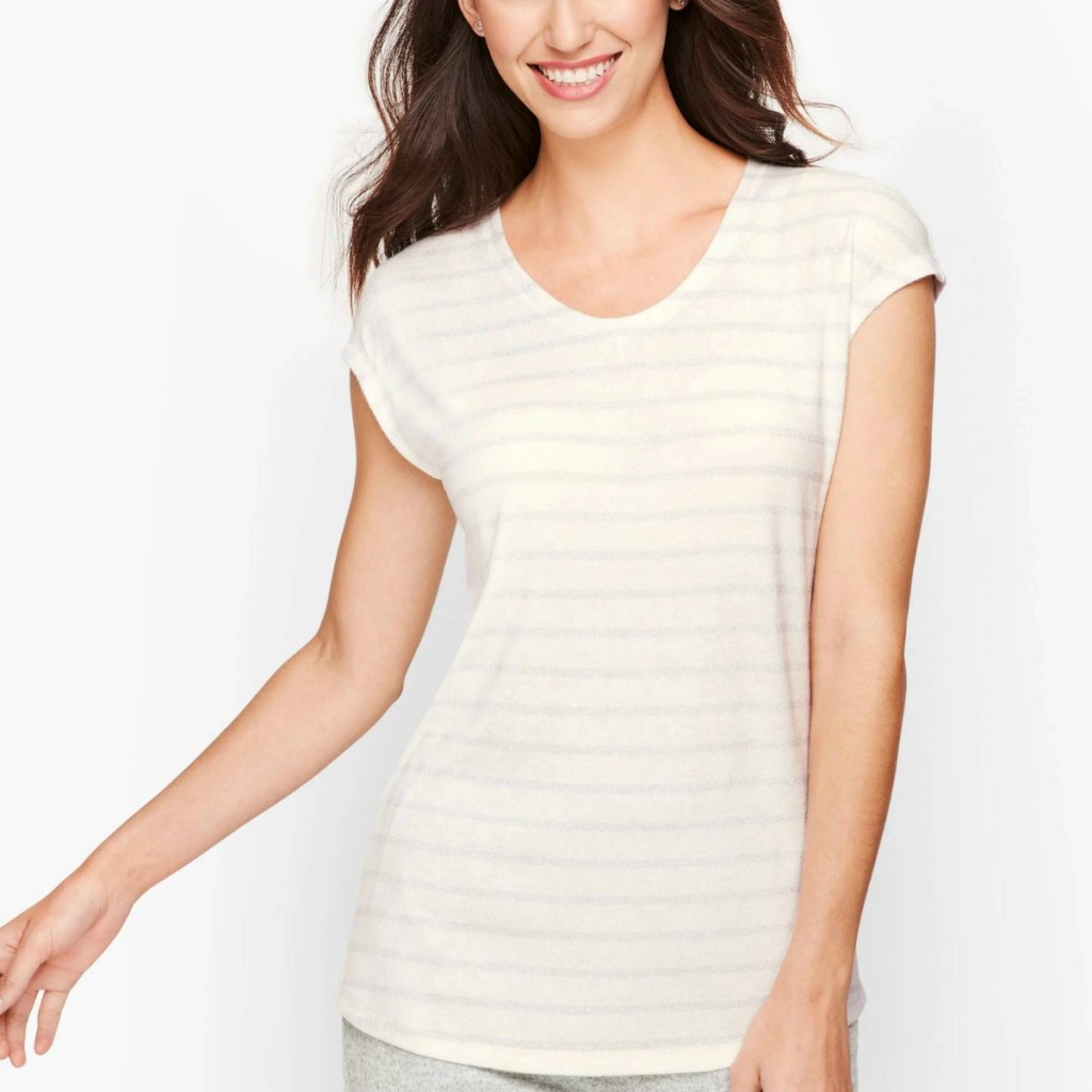 Woman wearing a long ivory tee with shimmering stripes