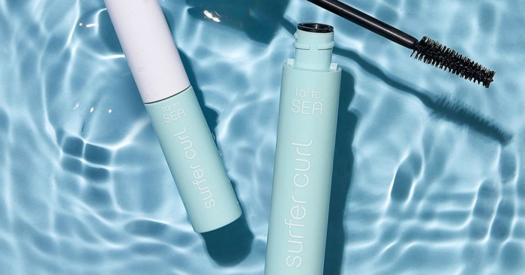 Two tubes of mascara in blue containers floating in shallow water