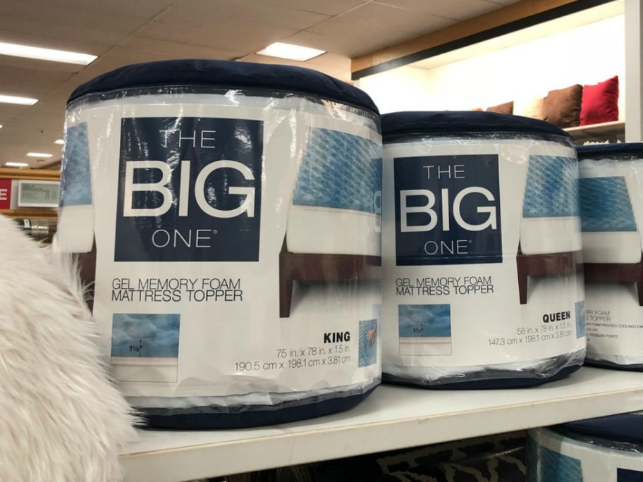 Several packages of gel memory foam mattress toppers on display on shelf in-store