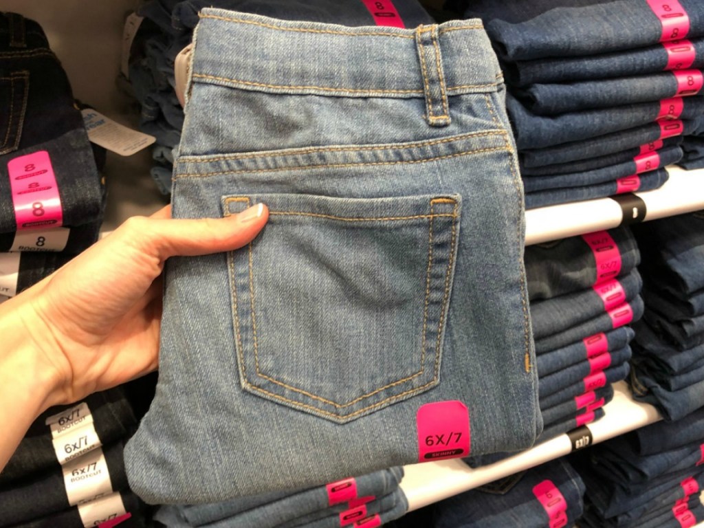 The Children's Place girls jeans fold and in hand near in-store display