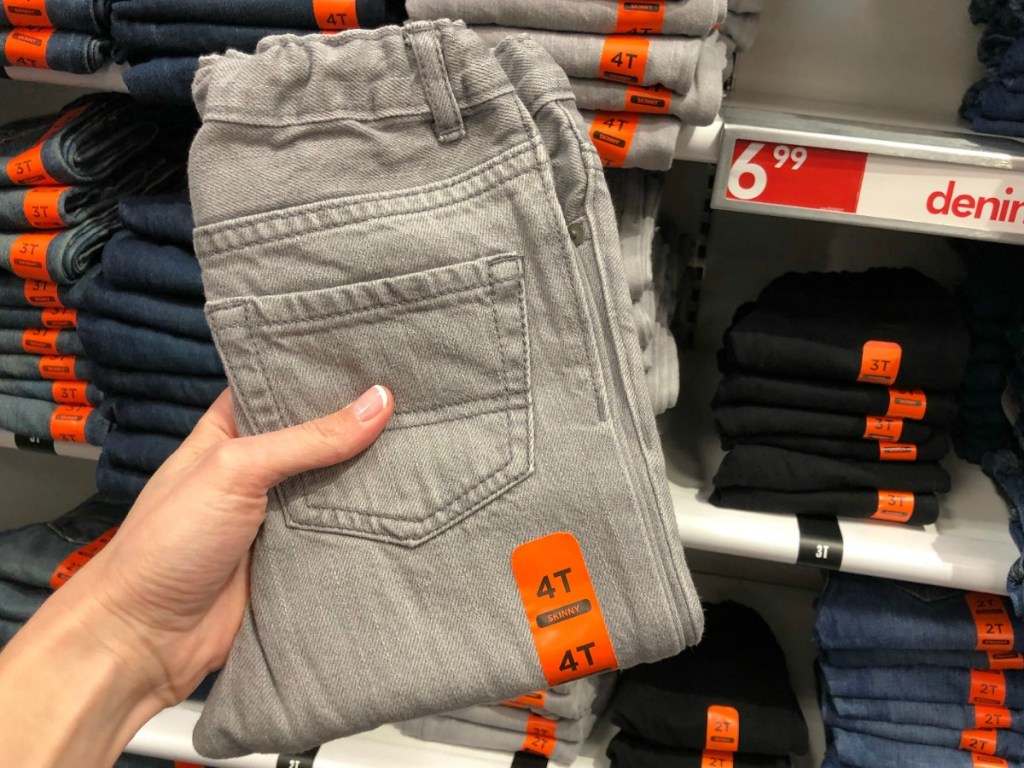 Pair of folded toddler jeans near in-store display