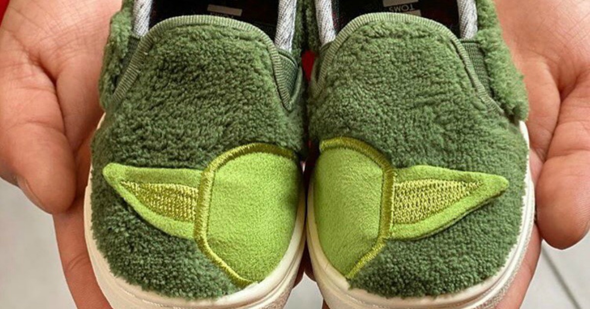 Tiny TOMS Yoda shoes in a pair of hands