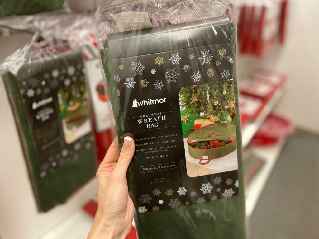 Green wreath storage bag in package in hand, in store