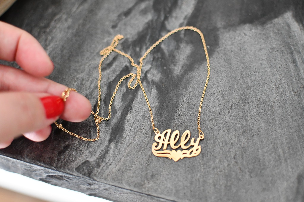 hand holding chain of name necklace