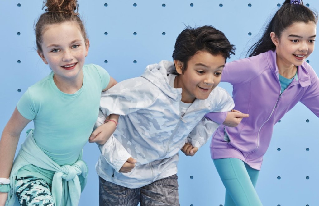 three kids wearing athletic apparel