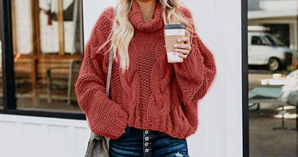 woman wearing rust red colored chunky knit sweater holding a coffee
