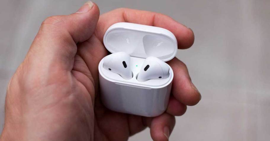 hand holding a case with apple airpods