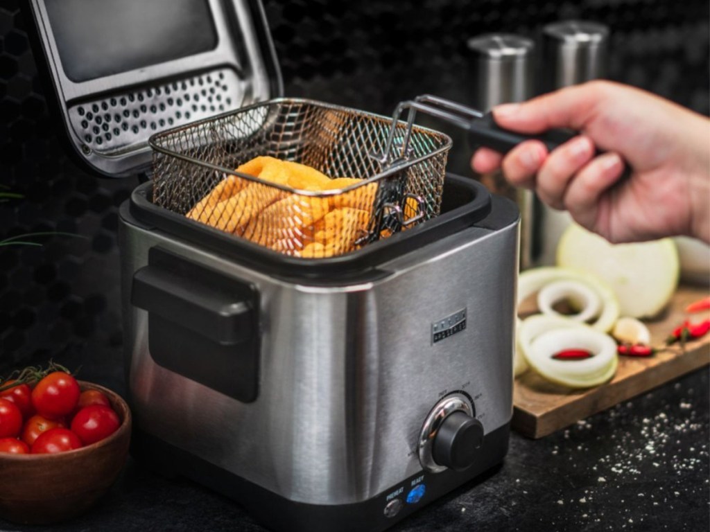 person holding basket of fries in a Bella Pro Series 1.6qt Stainless Steel Deep Fryer
