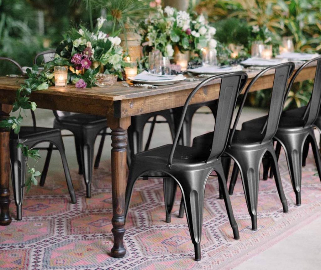 black metal chairs and dining room table set up for floral event