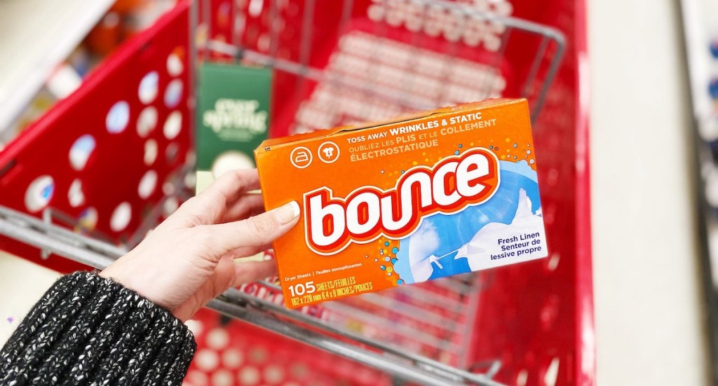 hand holding orange box of bounce dryer sheets with target cart in background - waste of money