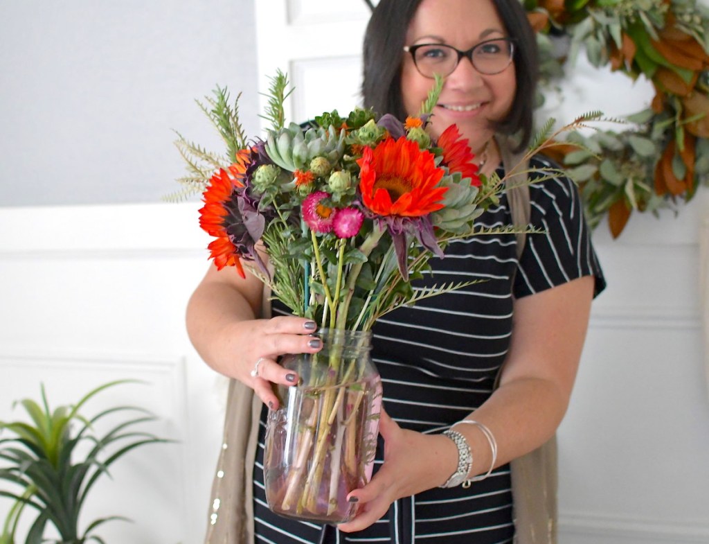 woman holding a bright colorful bouquet of flowers