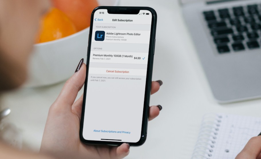 hand holding phone with apple app subscription cancelation on screen save money fast best way to save money saving
