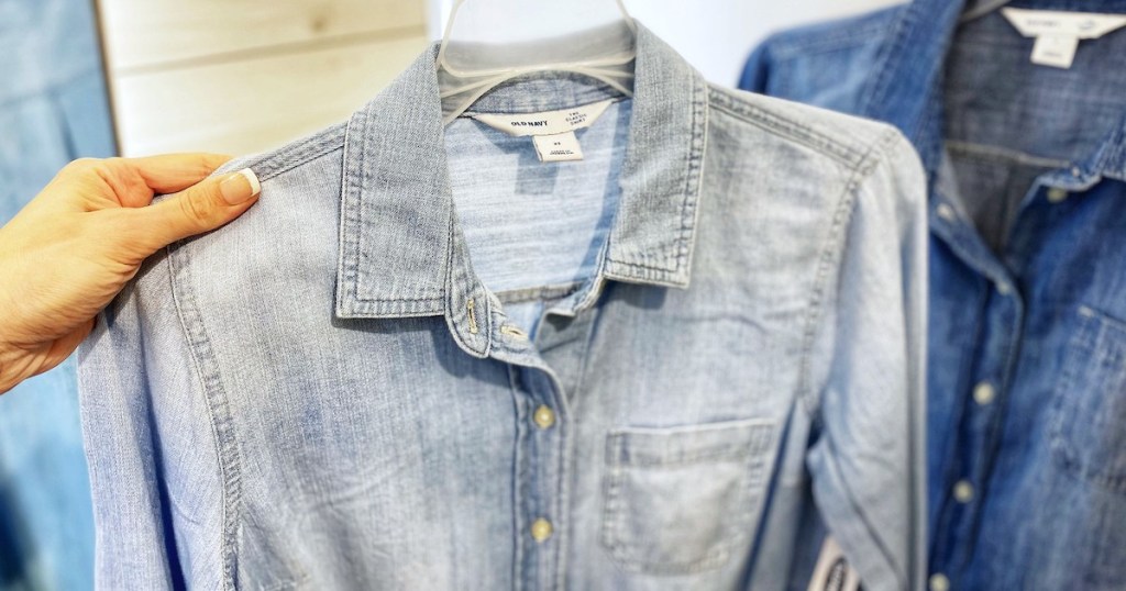 hand holding a light colored chambray denim shirt 