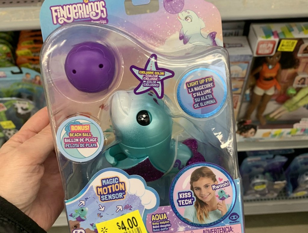 person holding fingerlings dolphin toy